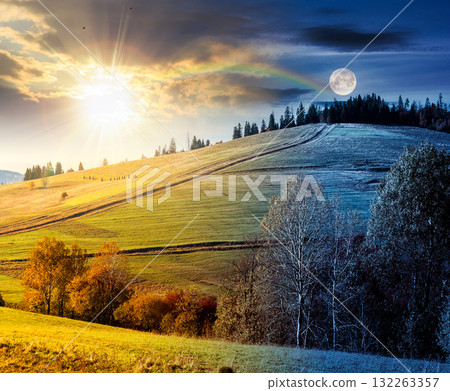 forest on grassy hill on autumn equinox. day and night time change concept. beautiful rural scenery with rolling pasture. mountainous countryside with sun and moon at twilight. warm october weather forest on grassy hill on autumn equinox. day and night time change concept. beautiful rural scenery with rolling pasture. mountainous countryside with sun and moon at twilight. warm october weather 132263357
