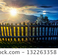 mountainous rural landscape on autumn equinox. day and night time change concept. field behind the wooden fence with sun and moon. scenery in fall season. forest on the hill. ridge in the distance 132263358
