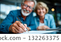 Smiling elderly couple signing important documents together, symbolizing trust, partnership, and financial security in later life 132263375