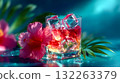Vibrant layered cocktail with ice cubes and pink hibiscus flower, representing summer refreshment and exotic relaxation 132263379