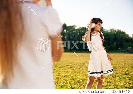 Fun, with tin can phone. Happy kids are on the summer field 132263740