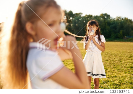 Fun, with tin can phone. Happy kids are on the summer field 132263741