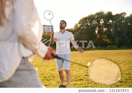 Conception of sports and hobby. Man with woman are playing badminton on the field 132263953