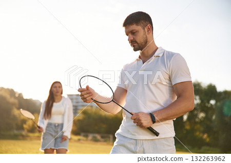 Man with woman are playing badminton on the field 132263962