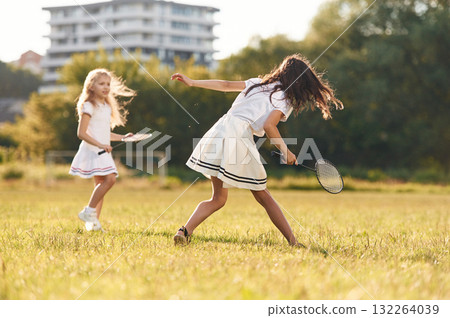 Game of badminton. Happy kids are on the summer field 132264039