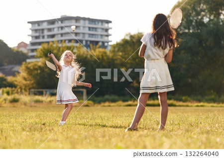 Game of badminton. Happy kids are on the summer field Game of badminton. Happy kids are on the summer field 132264040