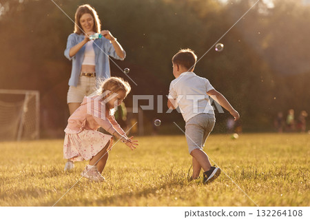 Woman with kids is on the summer field Woman with kids is on the summer field 132264108