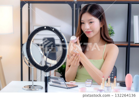 Young asian woman presenting and review cosmetic product with on social media. 132264136