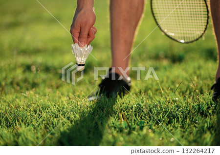 Close up view of man that is taking shuttlecock from the ground 132264217