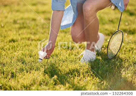 Close up view of woman that is taking shuttlecock from the ground 132264300