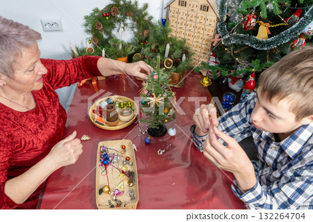 Grandmother and Grandson Decorating Christmas Tree Together 132264704