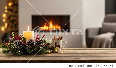Christmas centerpiece with a burning candle, pinecones, and a reindeer mug on a wooden table by a fireplace. 132266261