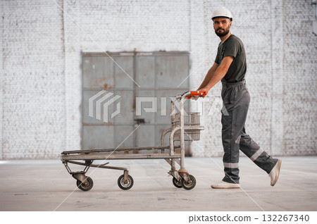 Pallet with nothing on it. Male worker is in the empty warehouse Pallet with nothing on it. Male worker is in the empty warehouse 132267340