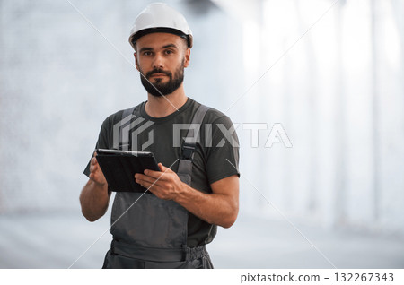 Beautiful portrait. Male worker is in the empty warehouse 132267343