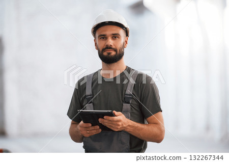 Beautiful portrait. Male worker is in the empty warehouse Beautiful portrait. Male worker is in the empty warehouse 132267344
