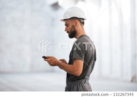 Side view, using digital tablet. Male worker is in the empty warehouse Side view, using digital tablet. Male worker is in the empty warehouse 132267345