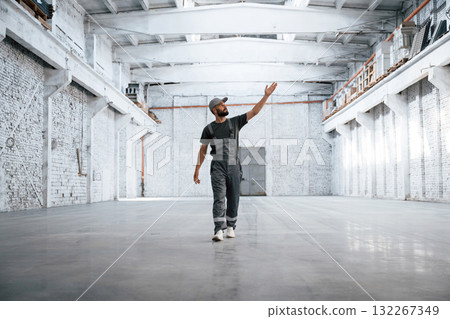 Huge area. Male worker is in the empty warehouse Huge area. Male worker is in the empty warehouse 132267349