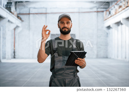 Okay, fine hand gesture. Male worker is in the empty warehouse Okay, fine hand gesture. Male worker is in the empty warehouse 132267360