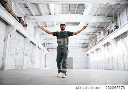 Hands on the sides, showing big area. Male worker is in the empty warehouse Hands on the sides, showing big area. Male worker is in the empty warehouse 132267373