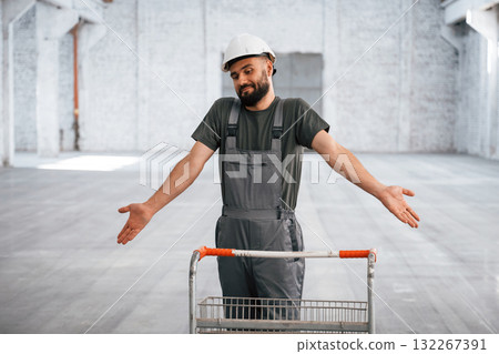 Pallet with nothing on it. Male worker is in the empty warehouse 132267391