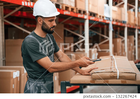 Taking a photo by smartphone of code on the box. Foreman is in the storehouse, shipping distribution business 132267424