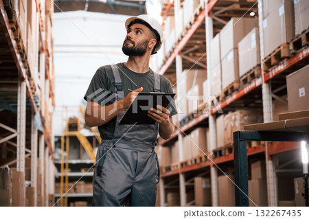 Quality control, with notepad. Foreman is in the storehouse, shipping distribution business Quality control, with notepad. Foreman is in the storehouse, shipping distribution business 132267435