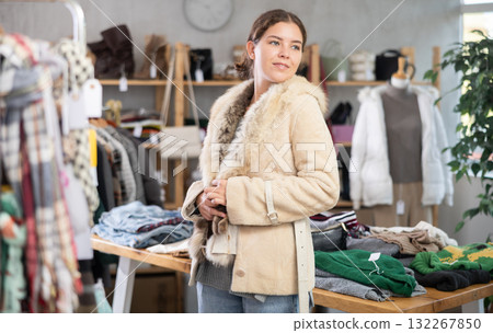 Preparing for fall and winter - girl try fur coat in clothes store 132267850