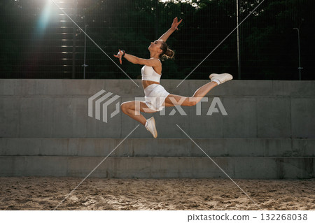 Up in the air, jumping. Young skinny fitness woman is outdoors 132268038