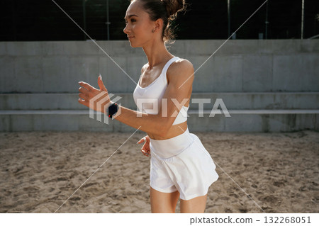 In white clothes. Young skinny fitness woman is outdoors In white clothes. Young skinny fitness woman is outdoors 132268051