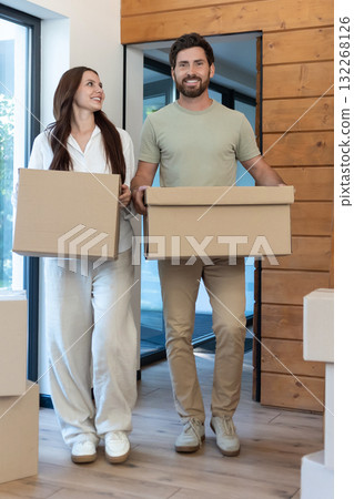 Man and woman carrying boxes into a new accommodation and feeling excited Man and woman carrying boxes into a new accommodation and feeling excited 132268126
