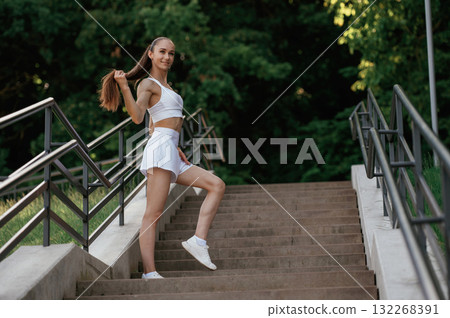 Posing, relaxed. Young skinny fitness woman is outdoors Posing, relaxed. Young skinny fitness woman is outdoors 132268391