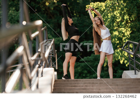 Getting ready, warm up exercises. Two sportive women are outdoors together 132268462