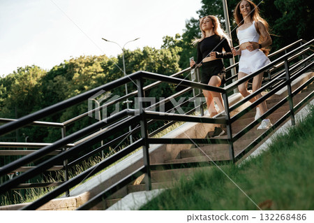 Railings and stairs. Two sportive women are outdoors together 132268486