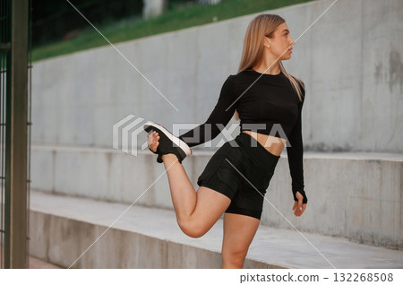 Warm up exercises. Beautiful fitness woman in sport clothes is outdoors Warm up exercises. Beautiful fitness woman in sport clothes is outdoors 132268508