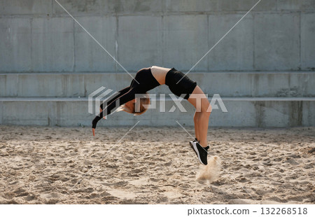 Doing tricks. Beautiful fitness woman in sport clothes is outdoors Doing tricks. Beautiful fitness woman in sport clothes is outdoors 132268518