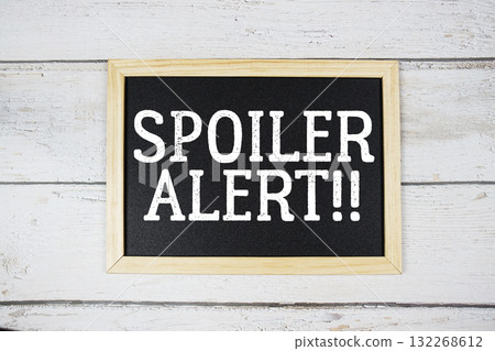 Spoiler Alert text with blackboard on wooden background 132268612