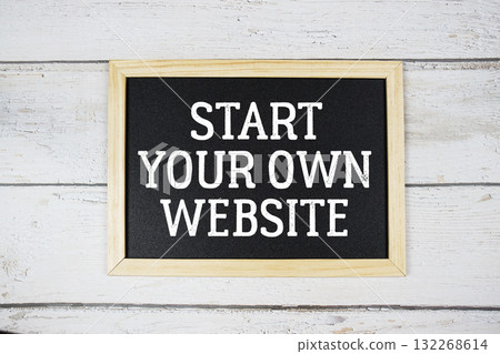 Start Your Own Website text with blackboard on wooden background 132268614