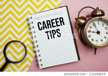 Career Tips text written on notepad with alarm clock and magnifying glass Career Tips text written on notepad with alarm clock and magnifying glass 132268629
