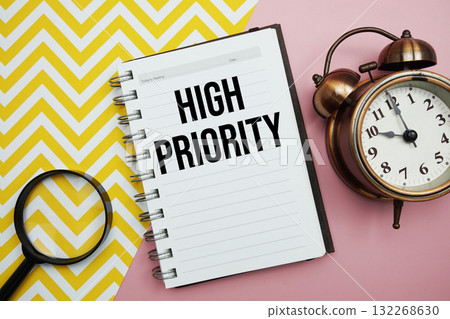 High Priority text written on notepad with alarm clock and magnifying glass 132268630