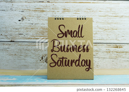 A brown card with the text "Small Business Saturday" against a rustic white wooden background A brown card with the text "Small Business Saturday" against a rustic white wooden background 132268645