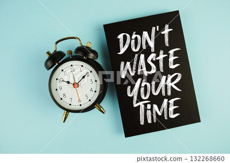 Don't Waste Your Time text with alarm clock on blue background Don't Waste Your Time text with alarm clock on blue background 132268660