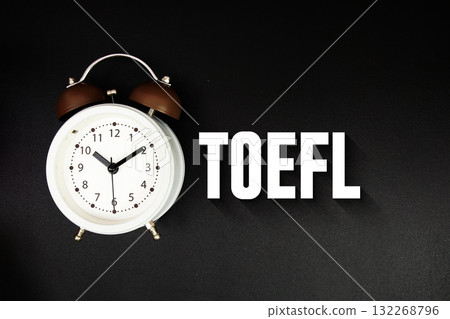 TOEFL text with alarm clock on black background 132268796