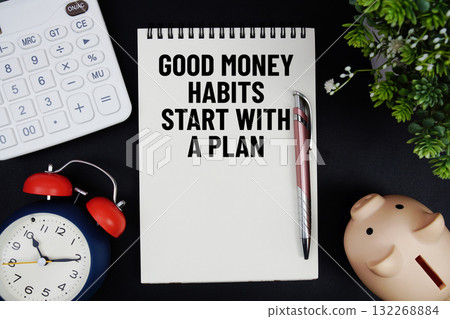 Good Money Habits Start With A Plan text with calculator with alarm clock and piggy bank on black background Good Money Habits Start With A Plan text with calculator with alarm clock and piggy bank on black background 132268884