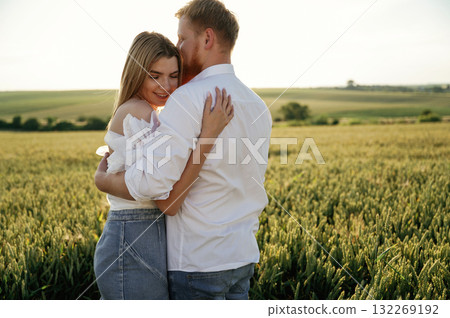 Closeness, embracing each other. Lovely couple are on the green agricultural field together 132269192