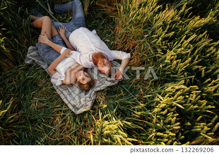 On the blanket, lying down, top view. Lovely couple are on the green agricultural field together 132269206
