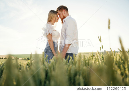 Lovely couple are on the green agricultural field together 132269425