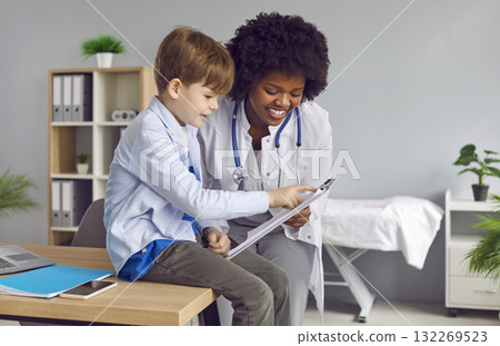 Happy African American woman pediatrician and a child look at something together 132269523