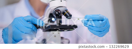 Scientist hands using microscope examining biological sample laboratory research analysis study discovery Scientist hands using microscope examining biological sample laboratory research analysis study discovery 132269629