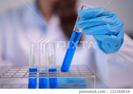 Scientist Conducts Laboratory Experiment Handling Chemical Solution in Test Tube for Scientific Research Analysis 132269638