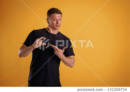 Banner in hands, copy space. Man is against background in the studio 132269734